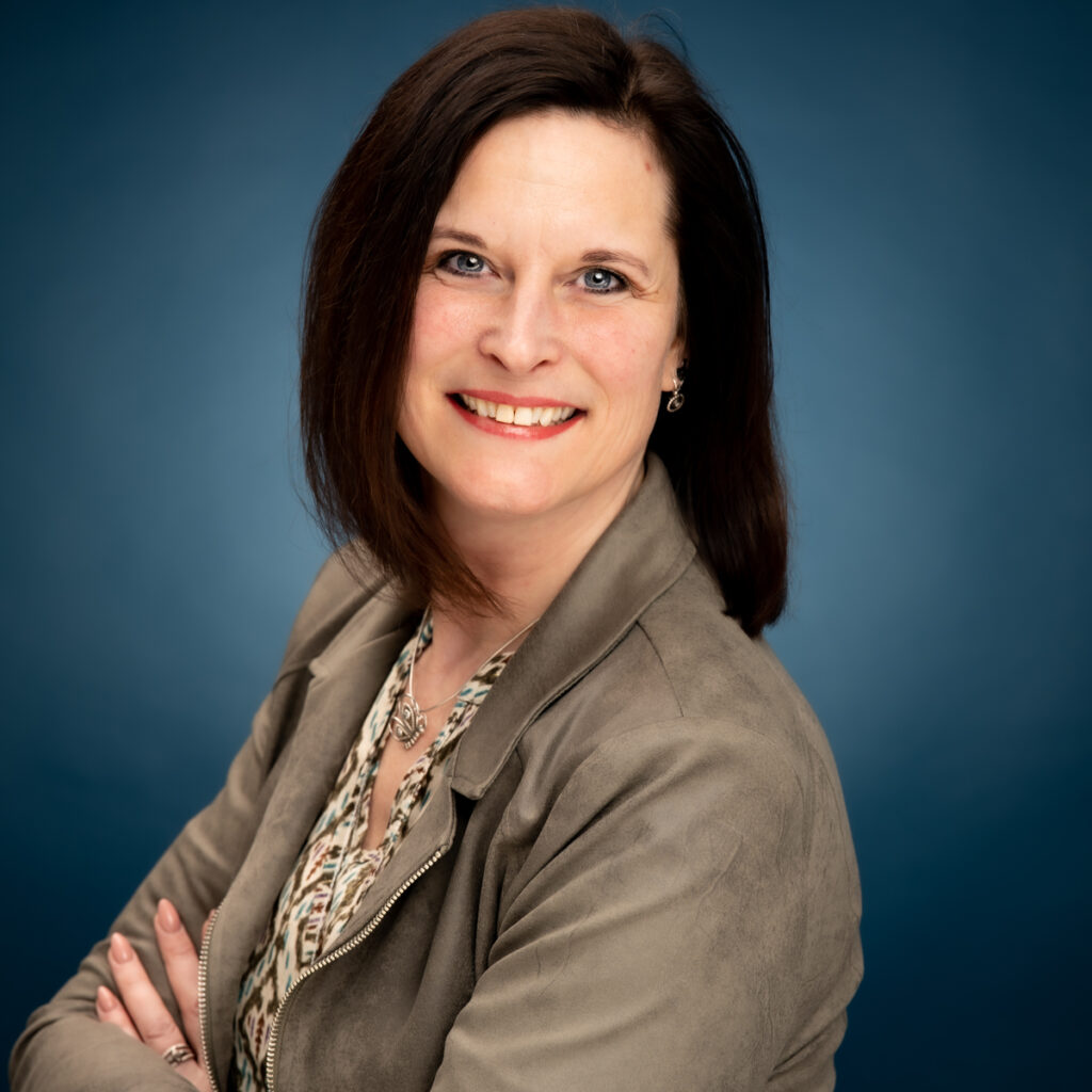 Sandra Corbet, oprichtster van Amley en Woko, poseert met haar armen over elkaar en kijkt in de camera – de drijvende kracht achter het educatieve EHBO-concept voor kinderen.