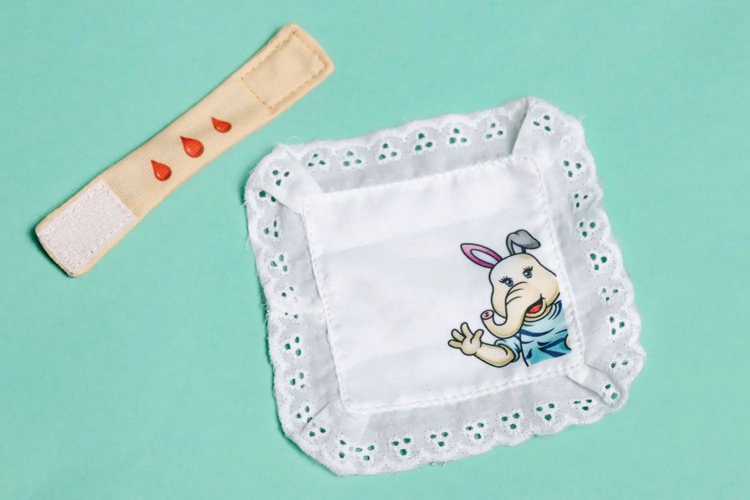 EHBO-accessoires uit Amley en Woko: pleister met bloeddruppels en een zakdoekje om spelenderwijs te leren hoe een bloedneus verzorgd wordt.